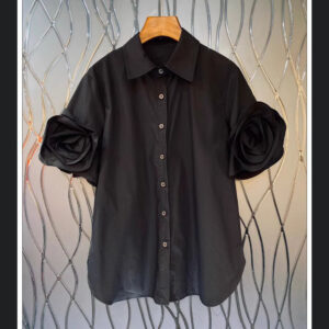 Сорочка чорного кольору прикрашена квіткою на рукавах